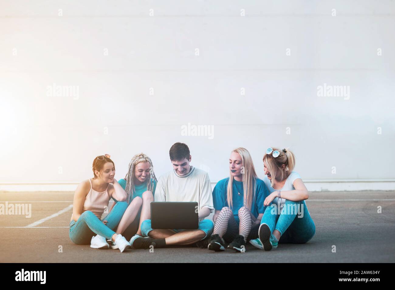 Group of young people looking at notebook computer outside Stock Photo