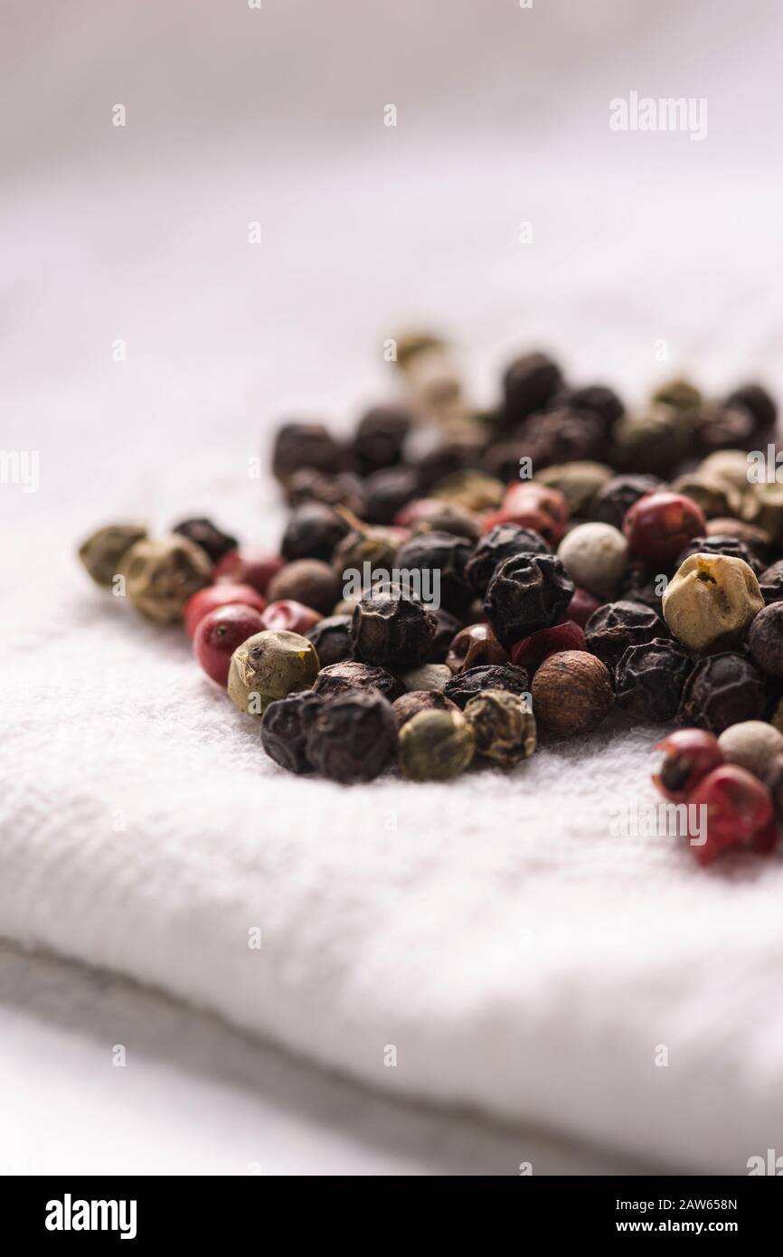 Pile of peppercorns on a white cloth napkin. Stock Photo