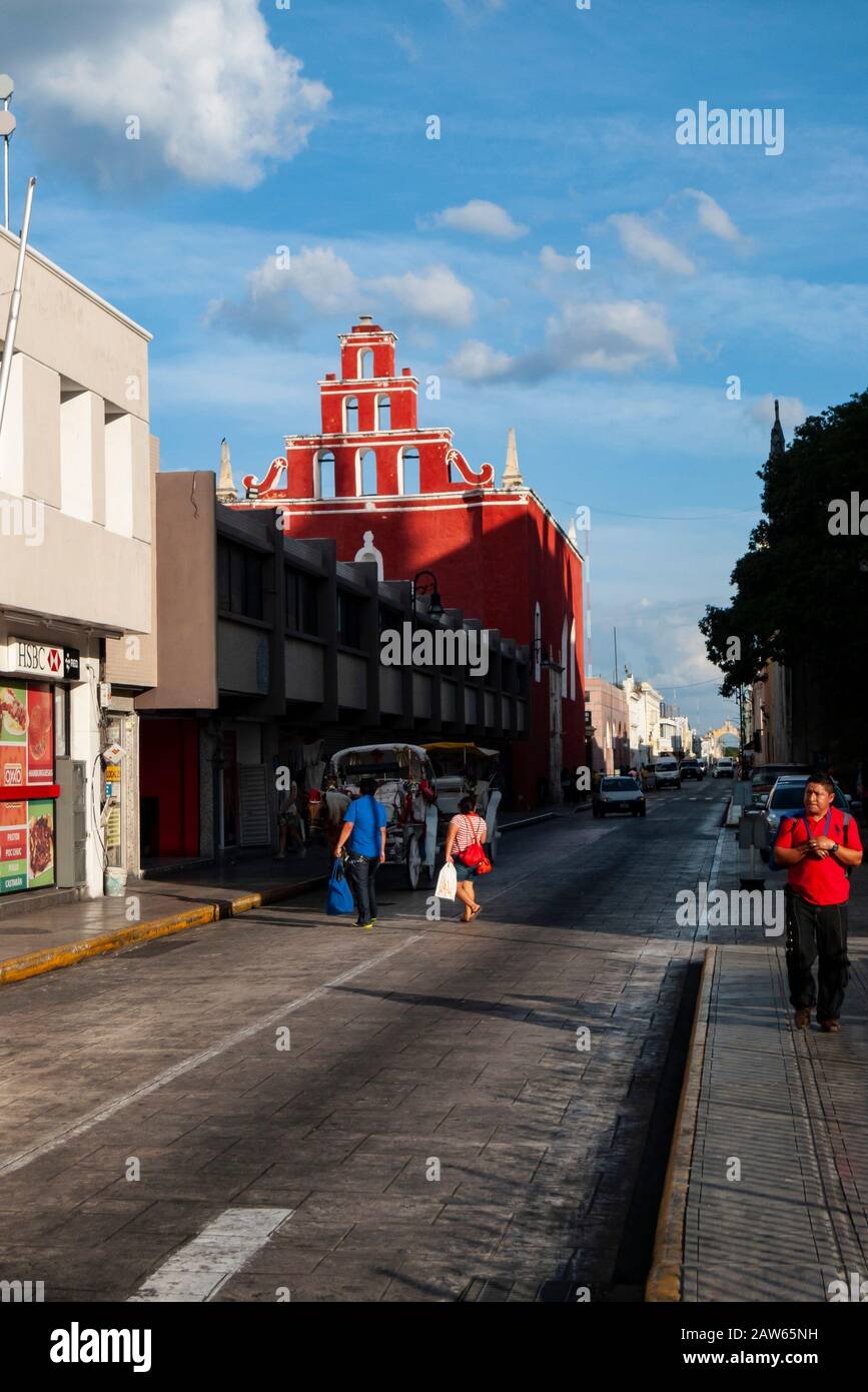 Looking down Calle 61 you can see the red facade of the Capilla de Nuestra Señora del Rosario Del Hospital De San Juan de Dios in Merida, Mexico. Stock Photo