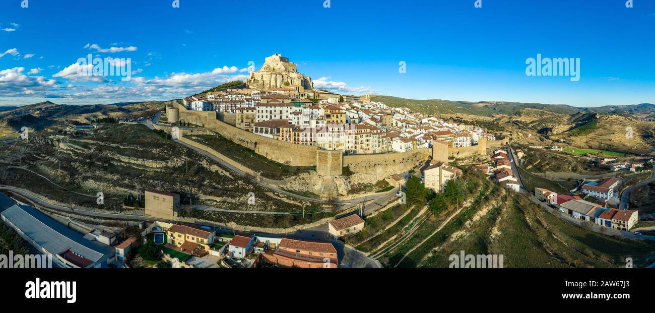 Aerial sunset view of Morella, medieval walled town with semi circular towers and gate houses crowed by a fortress on the rock in Spain Stock Photo