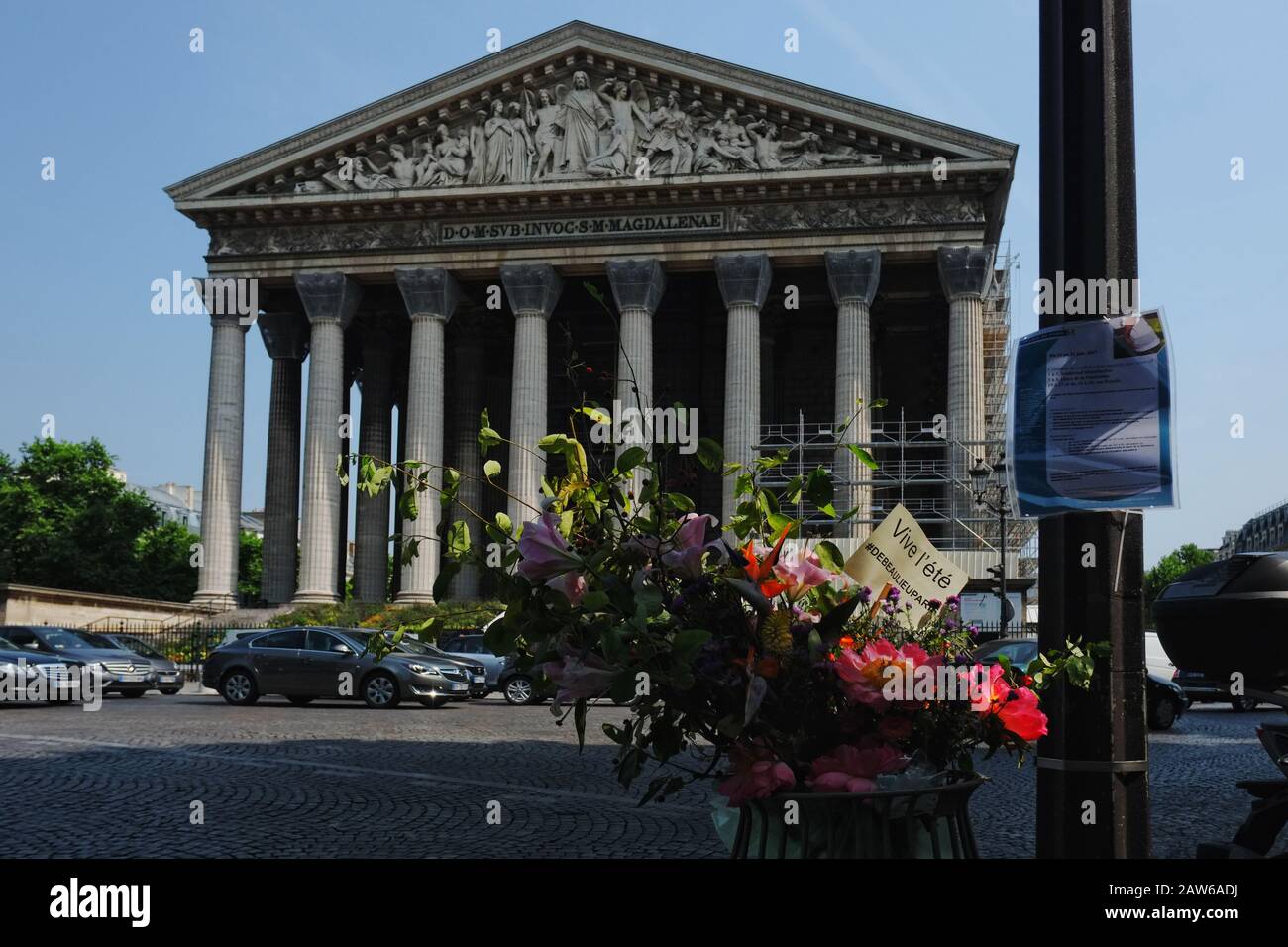 Front view with flowers, from across the road - L'église de la Madeleine,  Place de la Madeleine, 75008 Paris, France. Stock Photo