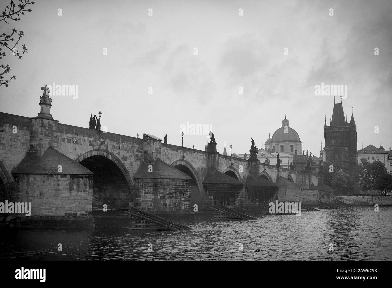 Charles Bridge in morning mist, from the river bank on  Malá Strana photographed in black and white - Karlův most over the Vltava River, Prague. Stock Photo