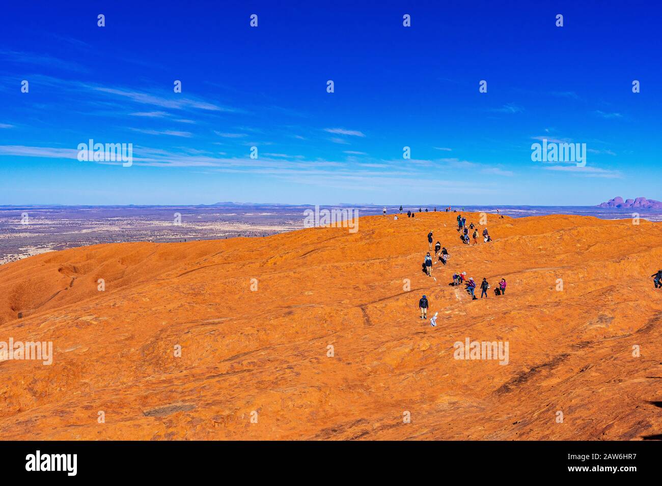 A line of tourists make the final trek along the top of Uluru in the final month prior to it being closed to climbers. Stock Photo