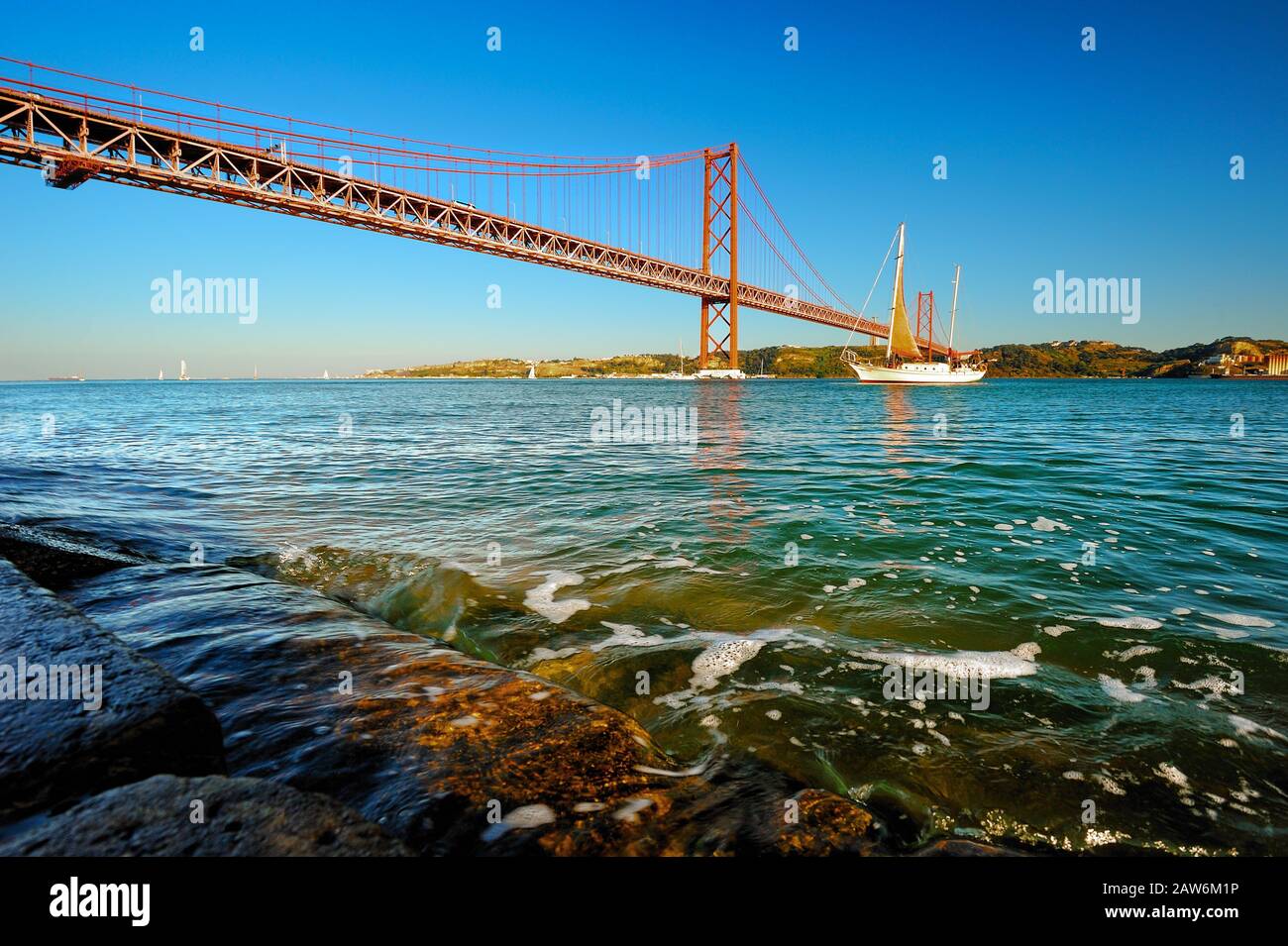 Beautiful view of the 25th of April Bridge (Ponte 25 de Abril) and Tagus river during sunset, Lisbon, Portugal Stock Photo