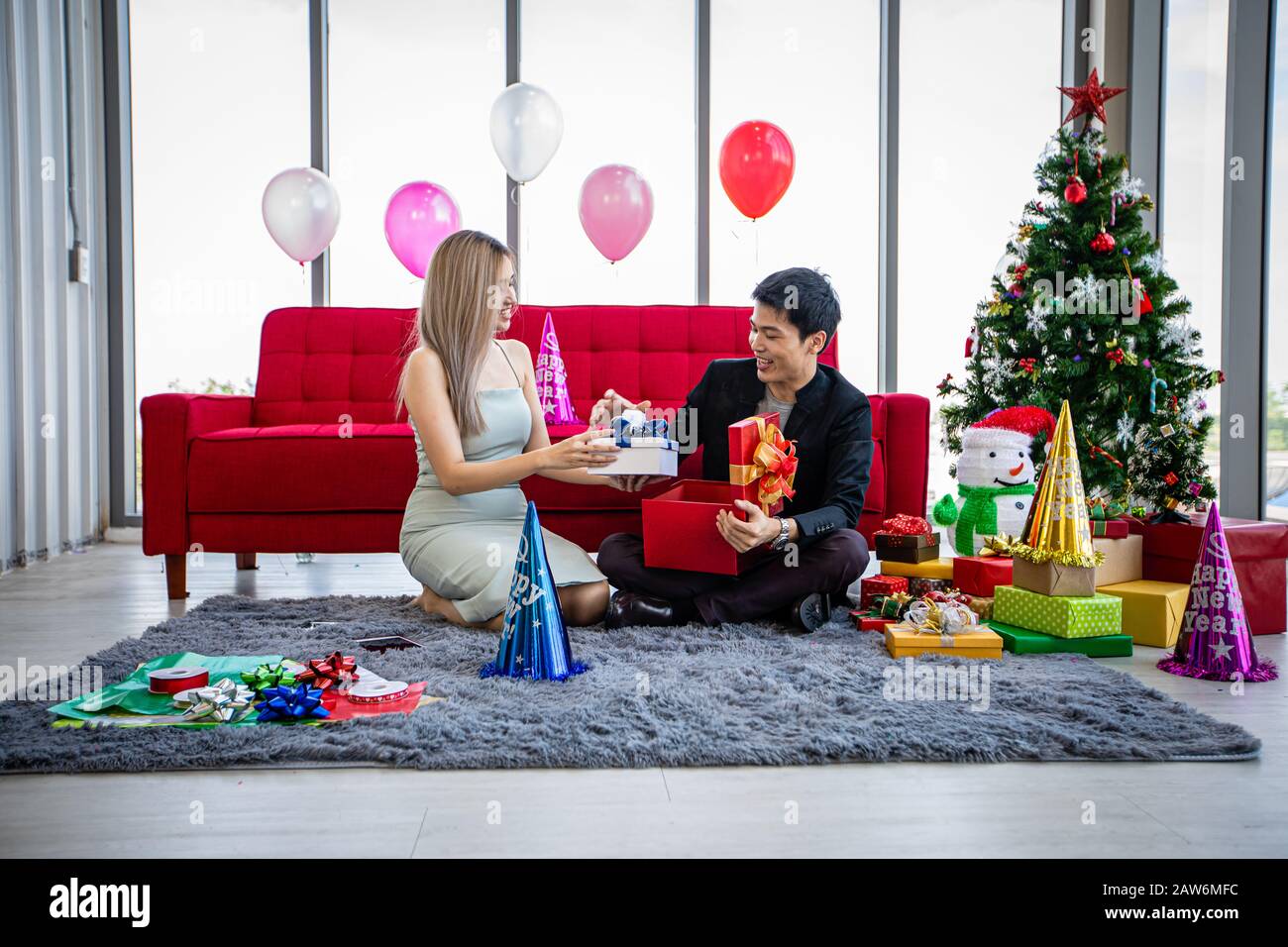 Asian couple lover are giving a gift box with Christmas gift in Christmas holiday and happy new year patty Stock Photo