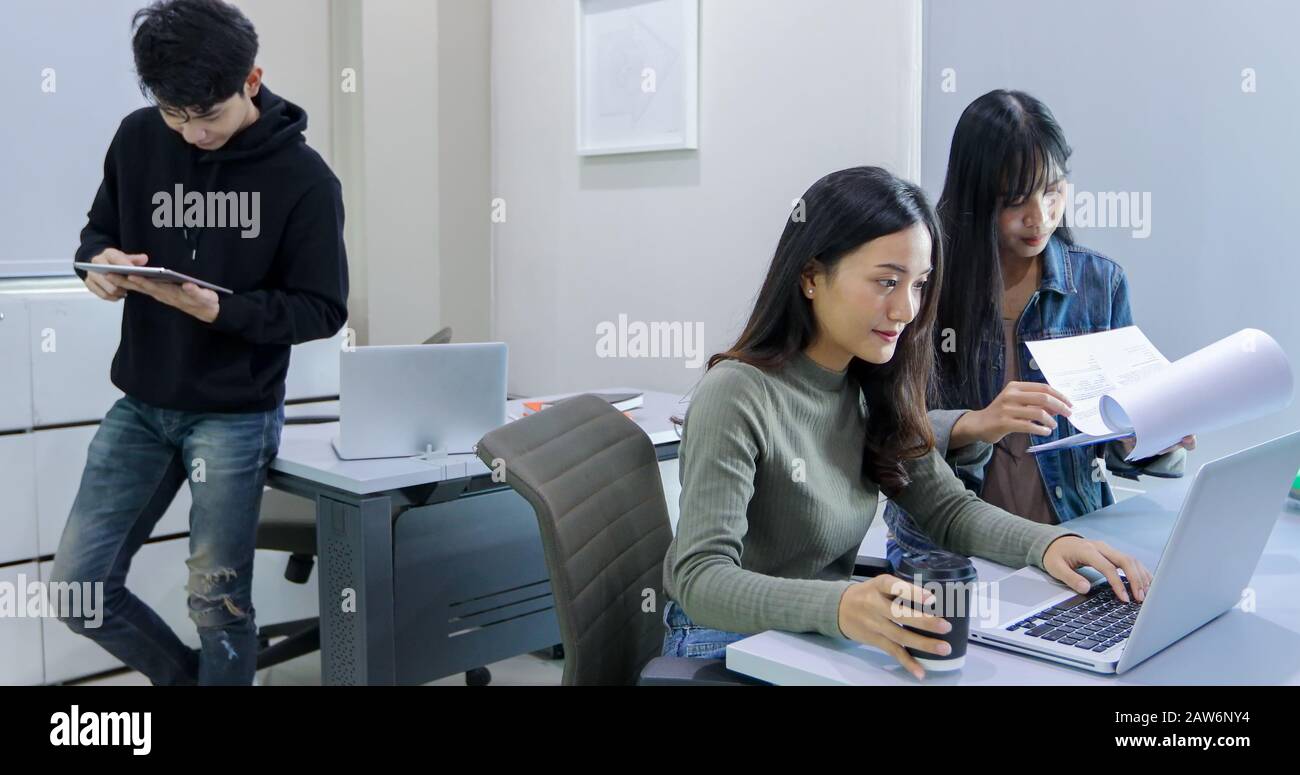 Group Students Smile and have fun and using tablet It also helps to share ideas in the work and project. And also review the book before the exam Stock Photo