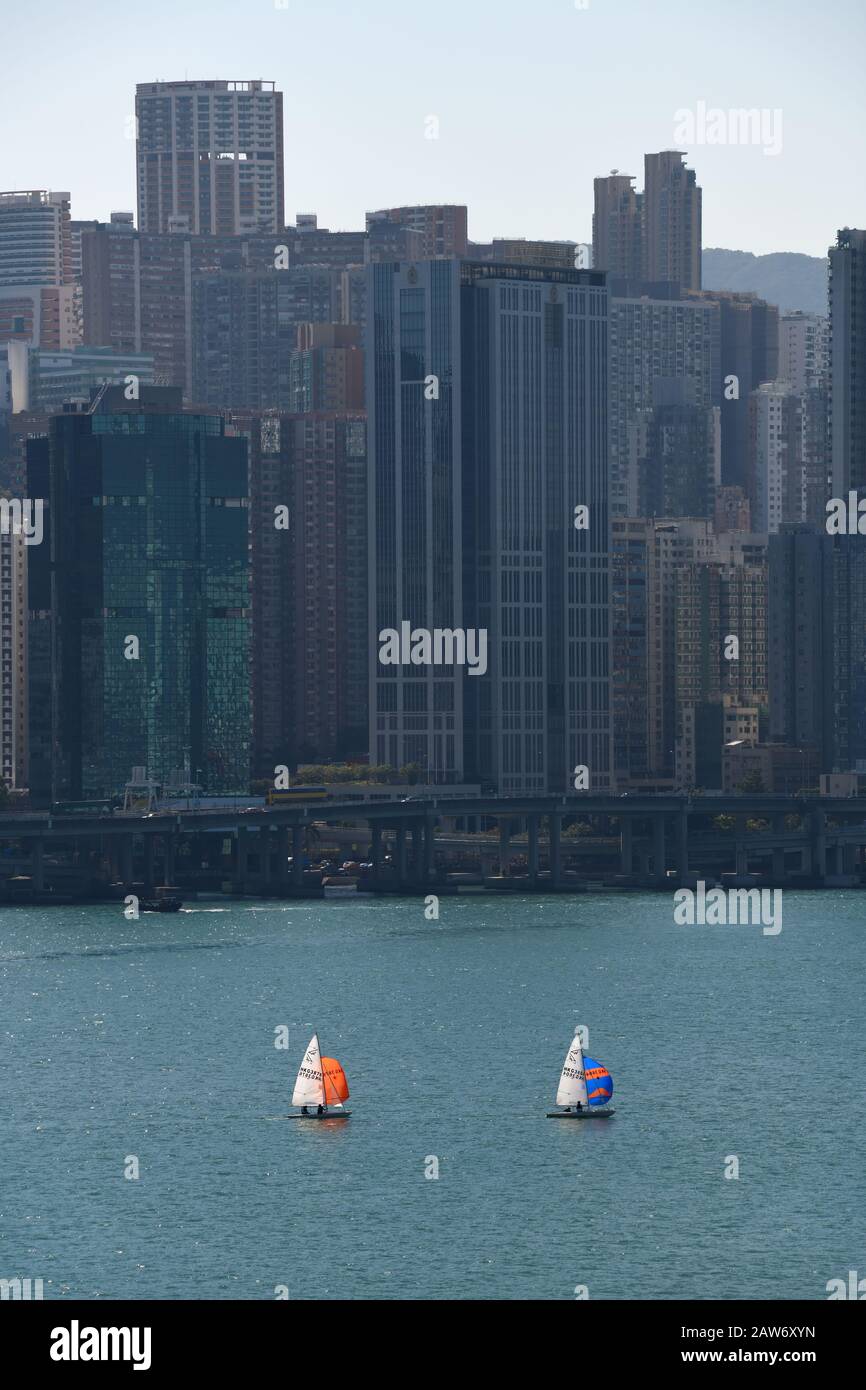 Small yachts are dwarfed by the tall buildings in Kowloon Bay, Hong Kong, China Stock Photo