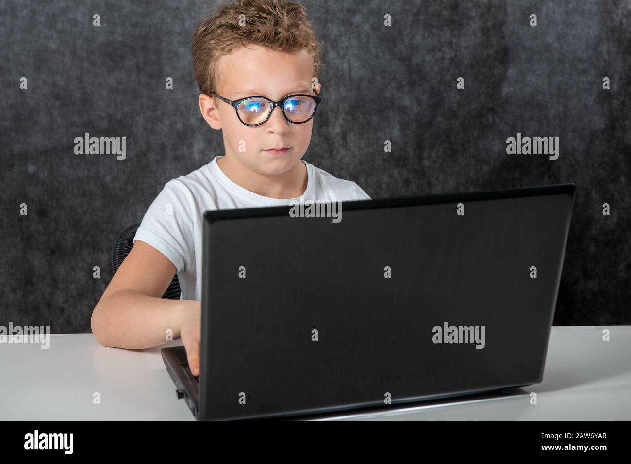 Happy boy sitting with a laptop computer Stock Photo - Alamy