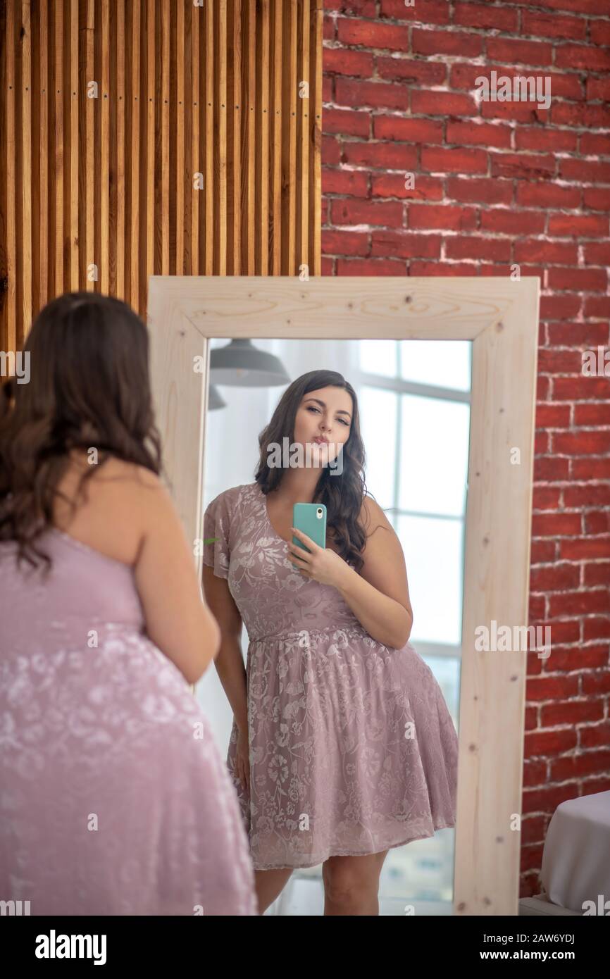 Young plus-size woman making selfie and feeling positive Stock