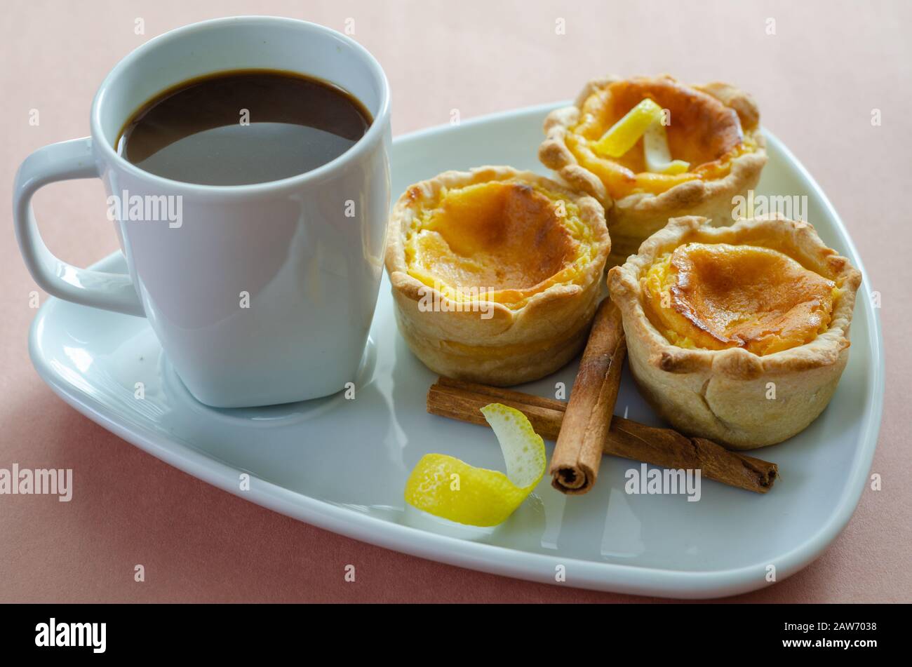 Portuguese egg tart pastry Pastel de nata on a plate with a cup of black coffee Stock Photo