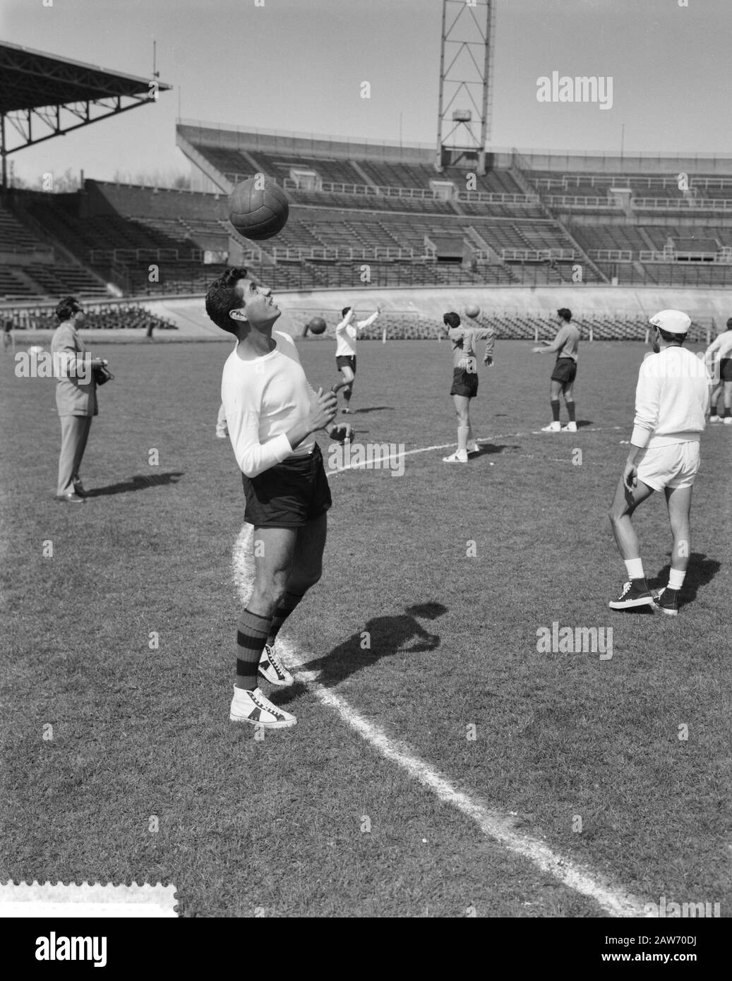 Training of Mexican soccer in the Olympic Stadium  [Mexican player holds the ball high to head] Date: April 18, 1961 Location: Amsterdam Keywords: sports stadiums, football, soccer, football Stock Photo