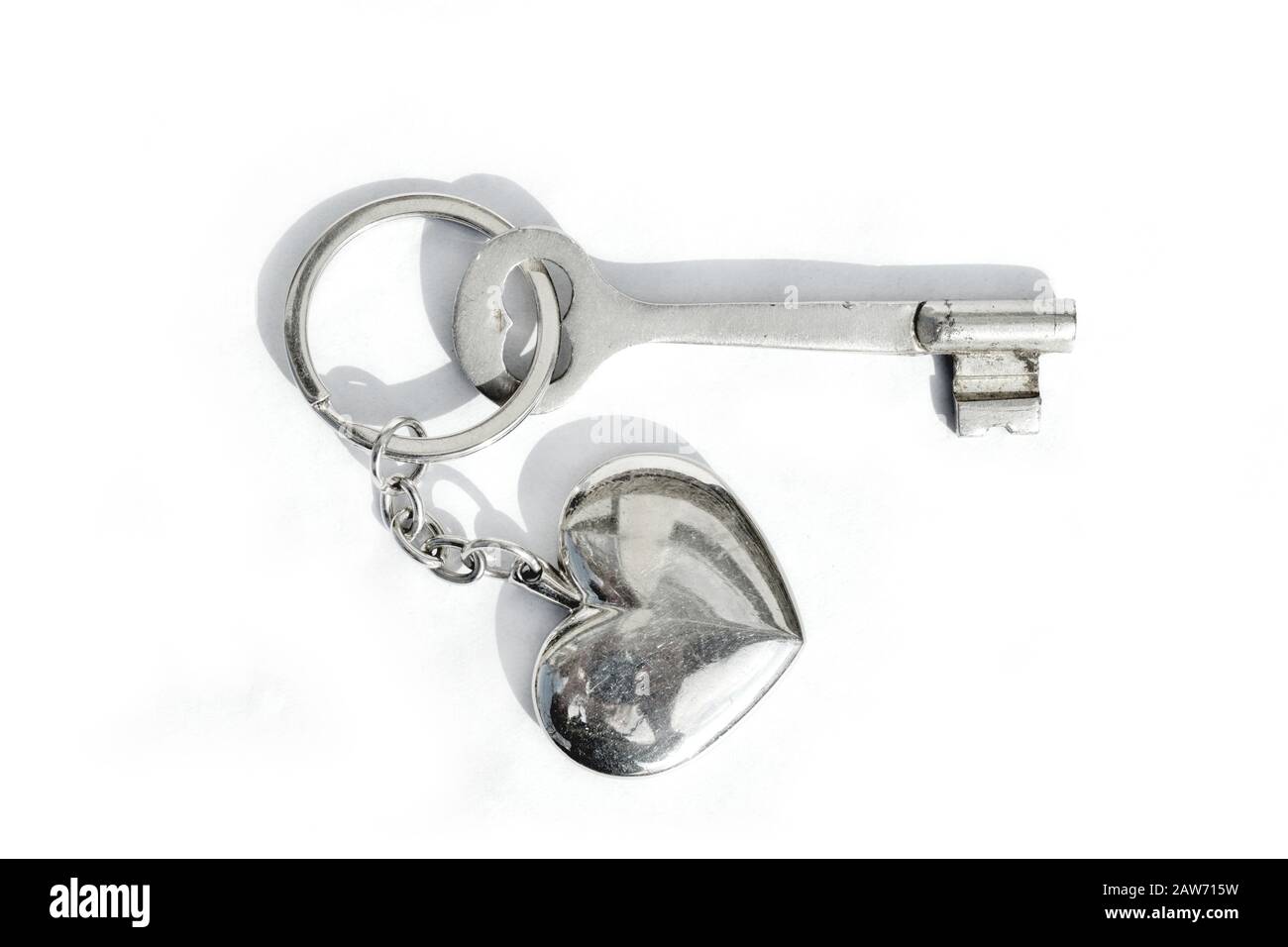 old key with metal heart on white paper background Stock Photo - Alamy
