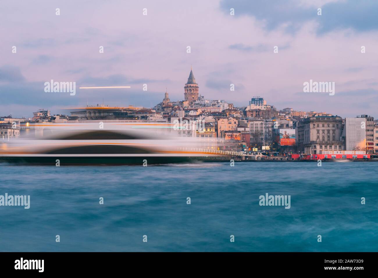 Istanbul, Turkey - Jan 15, 2020: Galata Tower with Ferry Boat in Golden Horn , Istanbul, Turkey, Stock Photo