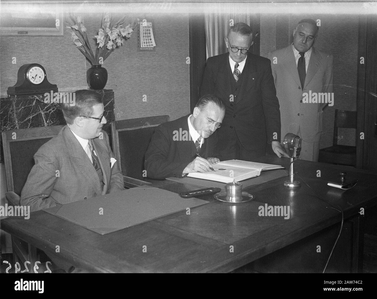 Social Affairs Minister Willem Drees signs Wederzijdigheid Social Insurance Treaty between Belgium and the Netherlands. Left the Belgian Minister of him L.E. Troclet Date: August 29, 1947 Keywords: international agreements, ministers Person Name: Drees, Willem (sr.), Troclet, L. E. Stock Photo