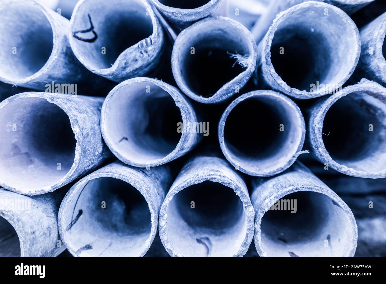 Low depth of field image of metal pipe stack in blue shade tone