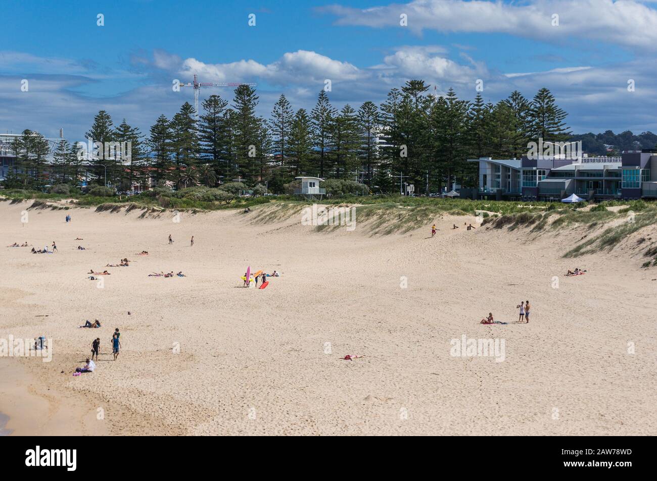 Travel background of picturesque sandy beach with incidental people. Happy vacation lifestyle, tourism landscape. Wollongong, Australia Stock Photo
