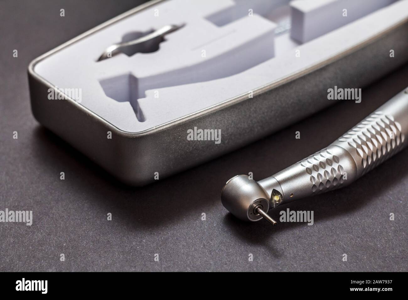 Highspeed dental handpiece and packing box on black background. Dental