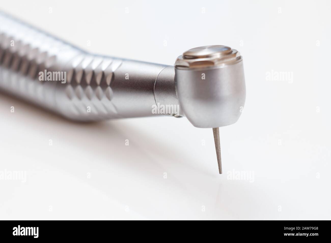 Head of high-speed dental handpiece with bur on white background. Dental instruments for dental treatment. Medical tools. Close-up view. Shallow depth Stock Photo