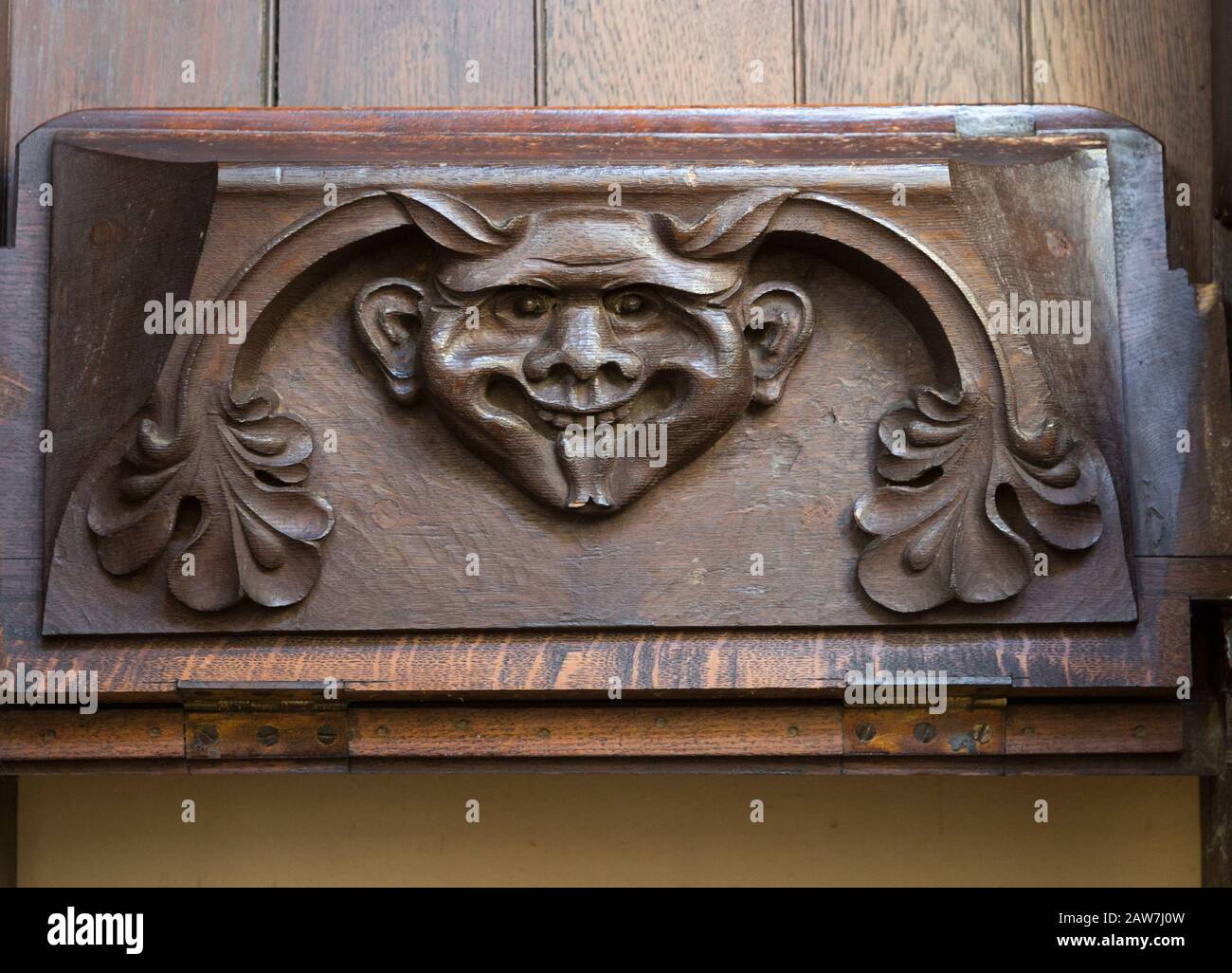 Church of Saint Mary of the Assumption, Ufford, Suffolk, England, UK grotesque devil face on misericord bench seat Stock Photo