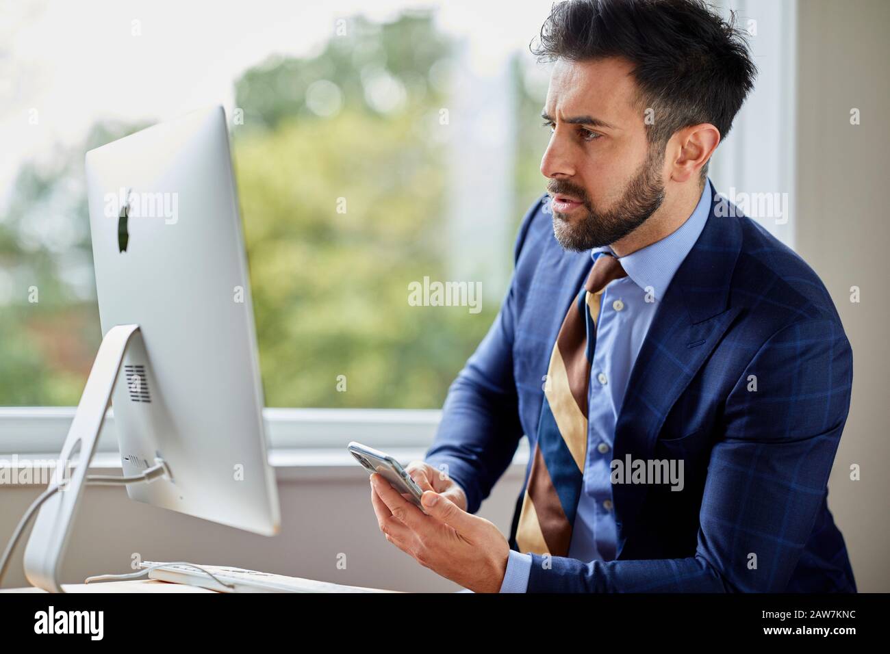 Man sat at computer thoughtful Stock Photo