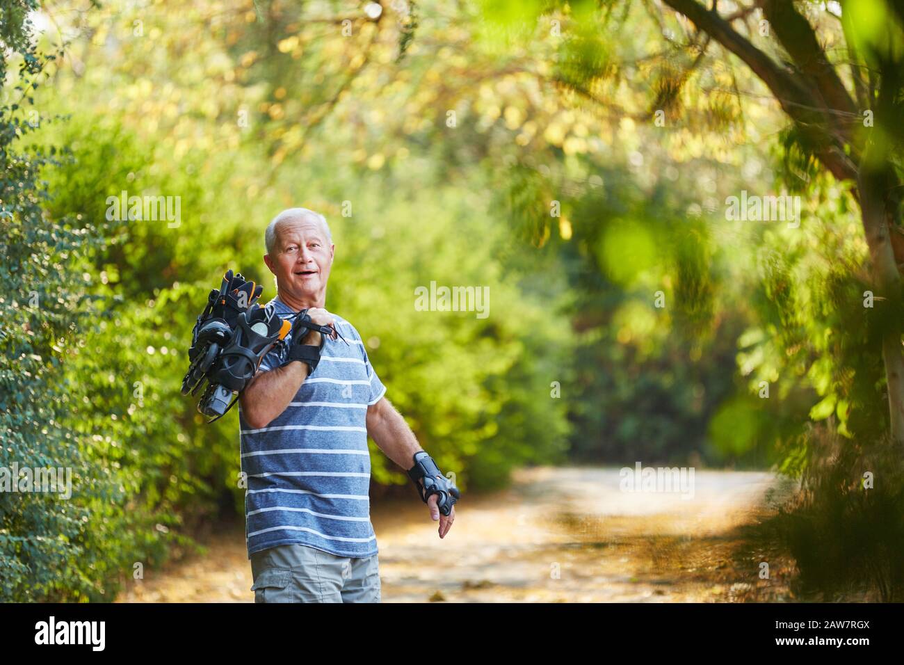 Happy senior as an inline skater in nature in summer Stock Photo