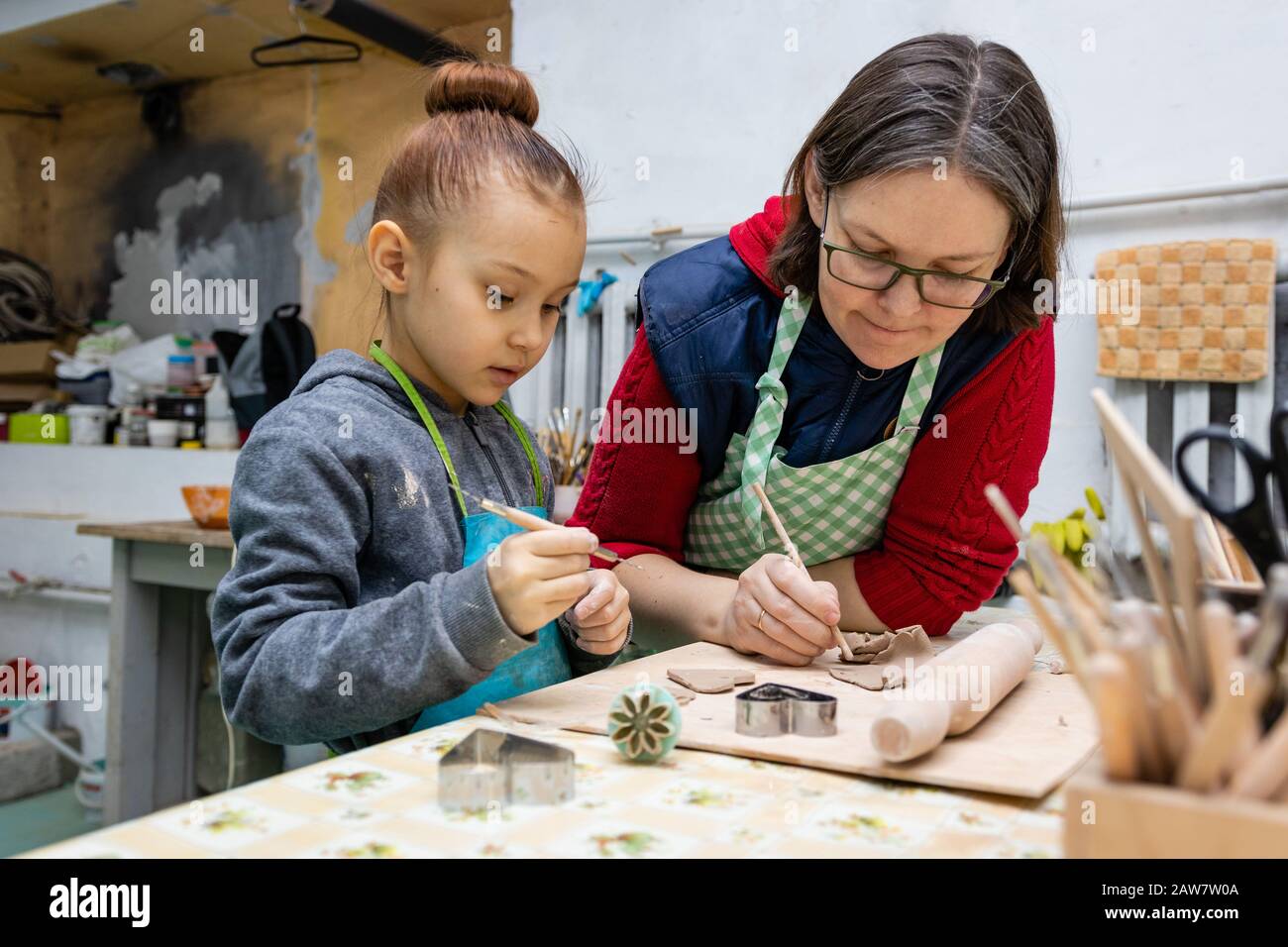 Girl 6 years old and a woman potter communicate in the process of ...