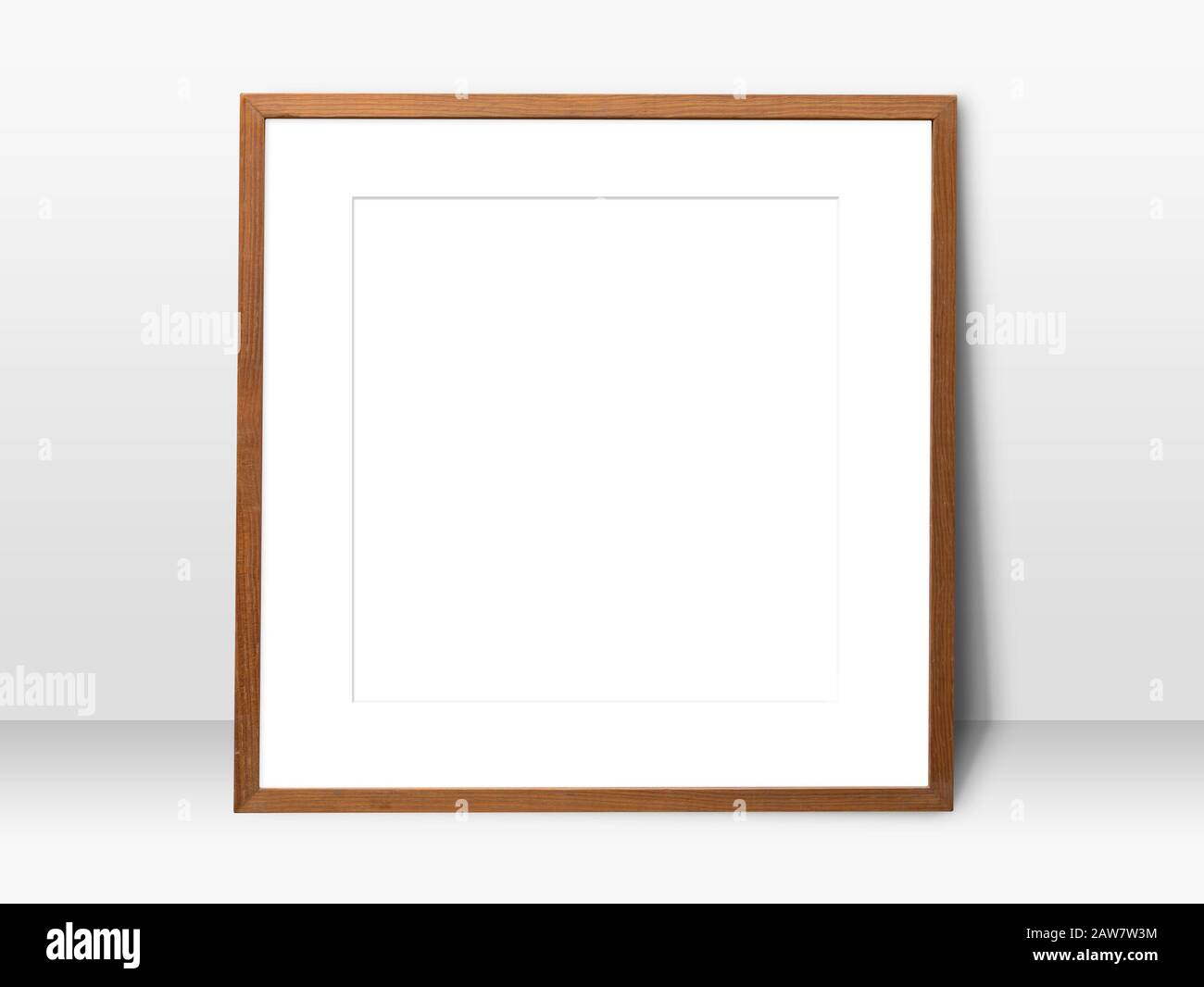 empty white space in wooden blank frame leaning against with white wall. simple blank photo frame for presentation or decorate background Stock Photo