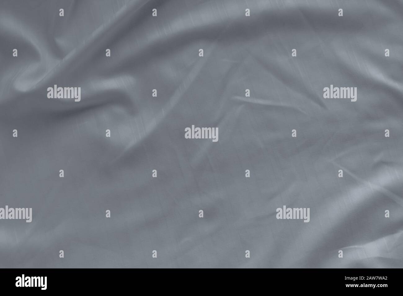 White linen bed sheet texture in hotel bedroom. Closeup detail of messy