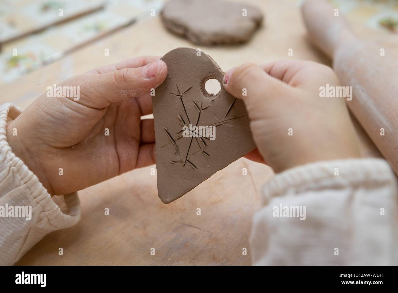 Children's hands make a heart out of clay, master class in a pottery workshop Stock Photo