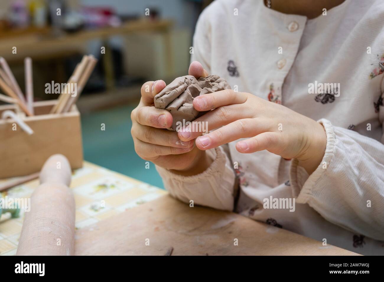 Children's hands make a heart out of clay, master class in a pottery workshop Stock Photo