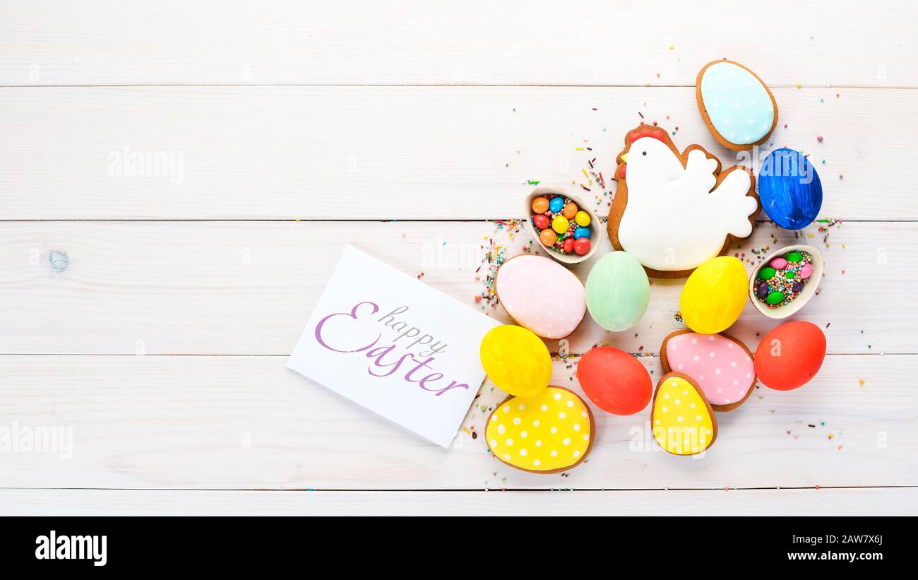 Easter greetings card with colorful gingerbread and sweets. On a white ...