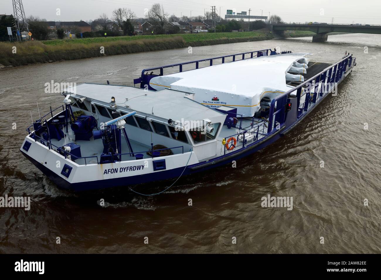 Broughton, Flintshire, North Wales, UK. 7th February 2020. The final A380 wing leaves the Airbus factory. The Dee River Craft Afon Dyfrdwy travels on the River Dee to the Port of Mostyn where the wing will then be shipped to Toulouse in France for final assembly. The customer for the last A380 is Emirates. Credit: Andrew Paterson/Alamy Live News Stock Photo