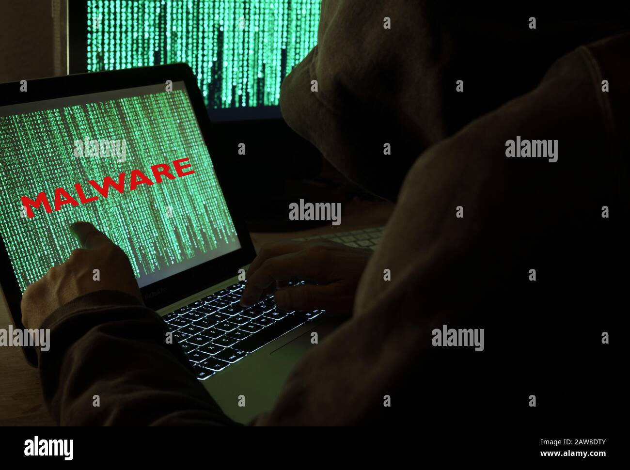 Hacker or person working on computers malware Stock Photo