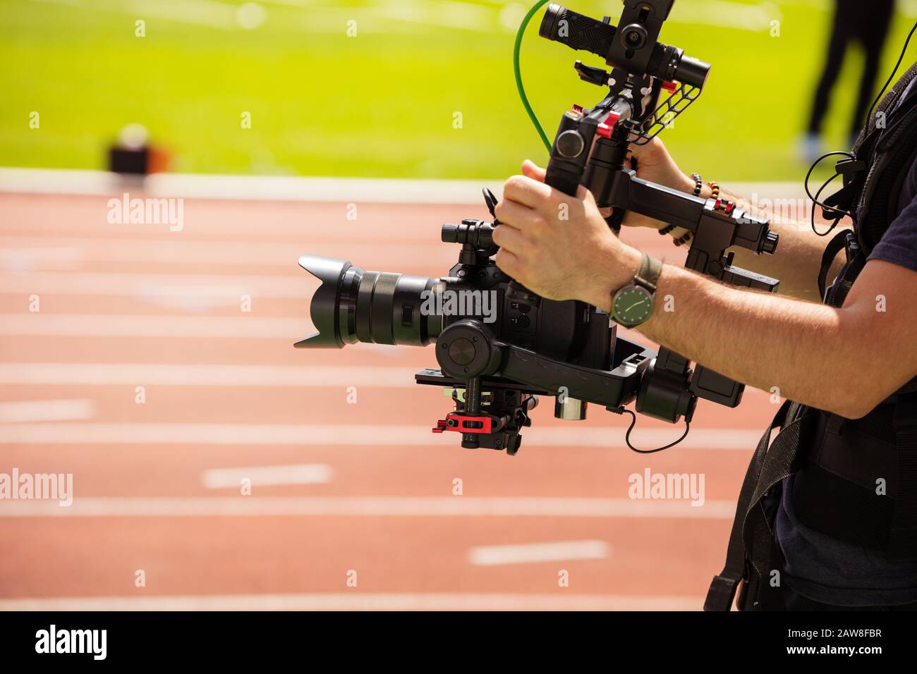 Close-up of camera-man shooting sport track competition view from profile Stock Photo