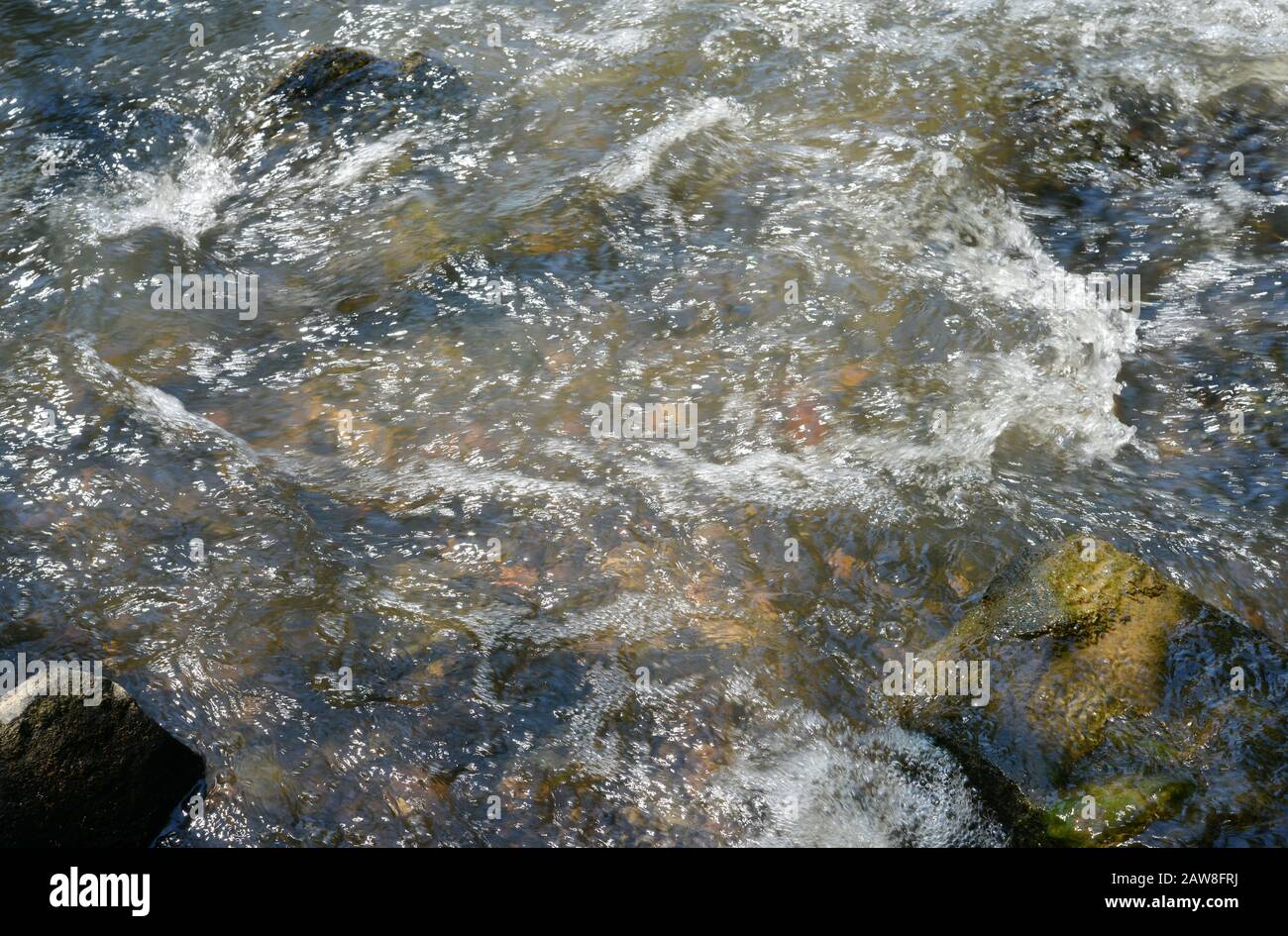 ein Bach mit schnell fliessendem Wasser mit Steinen Stock Photo