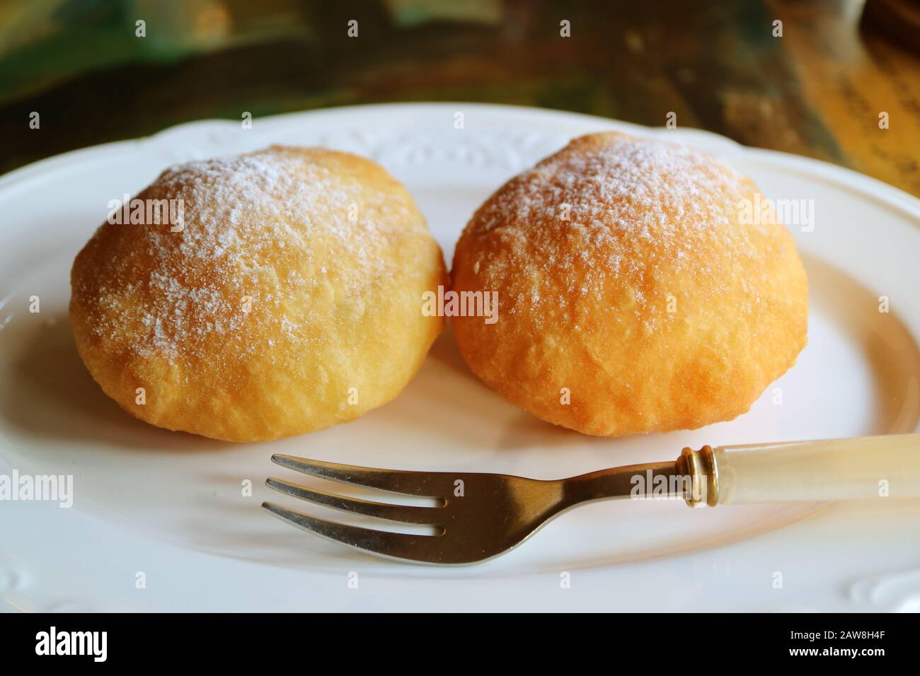 Pair of tasty fresh fried Georgian doughnuts sprinkled with icing sugar Stock Photo