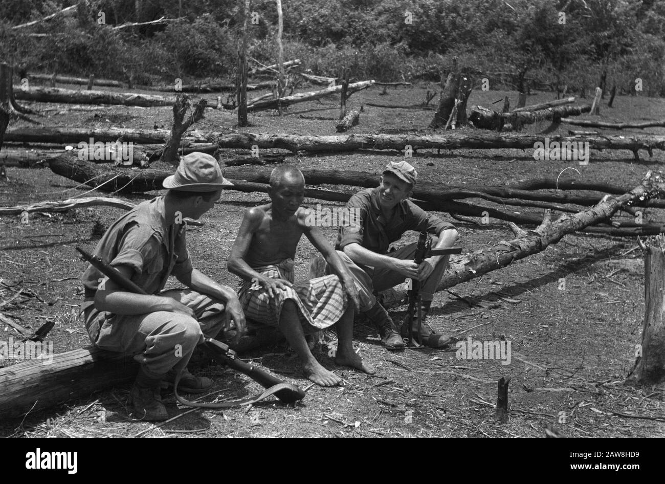 Tembangan Rambang, Tandjong Radja  Muara Koeang: when soldier Harry Blom from Oudewater with his pal Theo Coenraads (right) on patrol went, they met a colleague Harry. An Indonesian farmer, who had been ladang (dry rice field) to the editing. Stay sober but even if you're a farmer and you are just 'among colleagues. Naturally you stay sit down and discuss with serious face the important things in farming, though a little different than in the Netherlands ..... Date: October 1, 1948 Location: Indonesia, Muara Kuang, Dutch East Indies Stock Photo