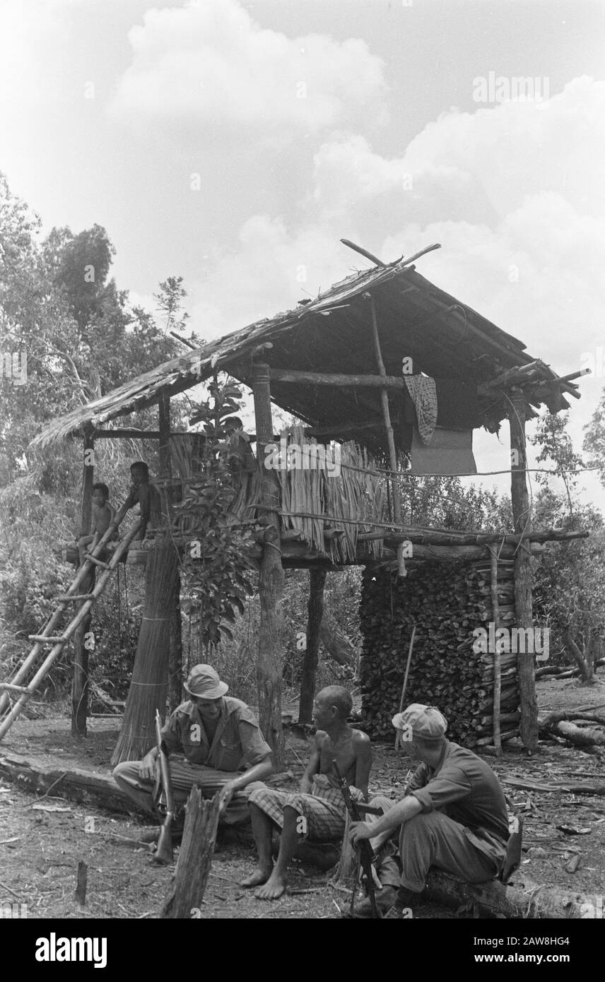 Tembangan Rambang, Tandjong Radja  Muara Koeang: when soldier Harry Blom from Oudewater with his pal Theo Coenraads (right) on patrol went, they met a colleague Harry. An Indonesian farmer, who had been ladang (dry rice field) to the editing. Stay sober but even if you're a farmer and you are just 'among colleagues. Naturally you stay sit down and discuss with serious face the important things in farming, though a little different than in the Netherlands ..... Date: October 1, 1948 Location: Indonesia, Muara Kuang, Dutch East Indies Stock Photo