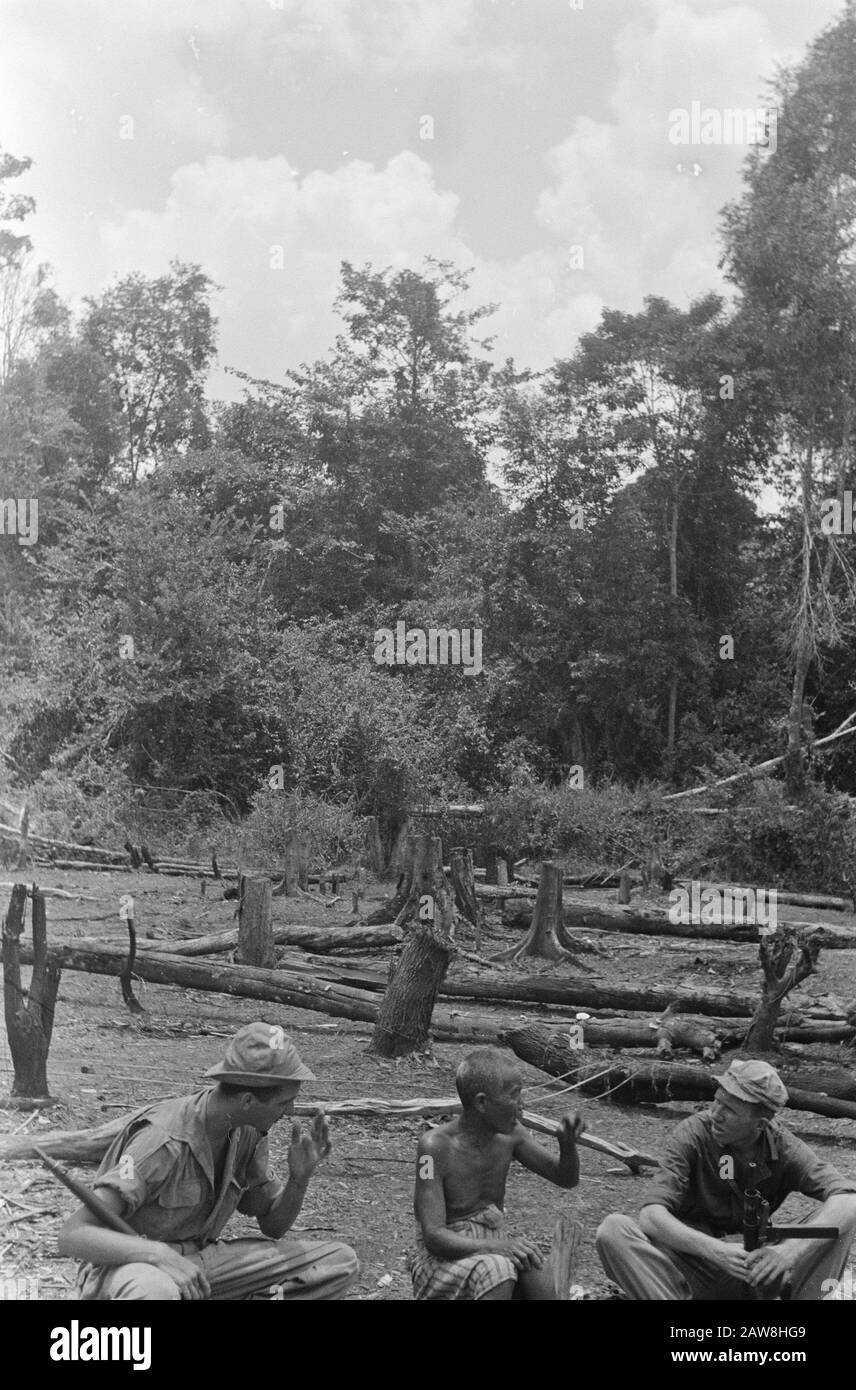 Tembangan Rambang, Tandjong Radja  Muara Koeang: when soldier Harry Blom from Oudewater with his pal Theo Coenraads (right) on patrol went, they met a colleague Harry. An Indonesian farmer, who had been ladang (dry rice field) to the editing. Stay sober but even if you're a farmer and you are just 'among colleagues. Naturally you stay sit down and discuss with serious face the important things in farming, though a little different than in the Netherlands ..... Date: October 1, 1948 Location: Indonesia, Muara Kuang, Dutch East Indies Stock Photo