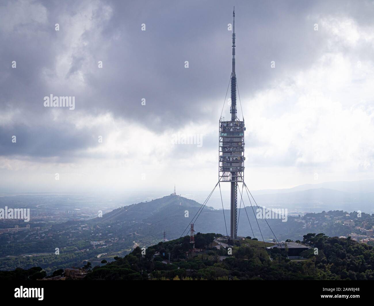Torre de Collserola tower located on the Tibidabo hill in the Serra de Collserola in cloudy day Stock Photo