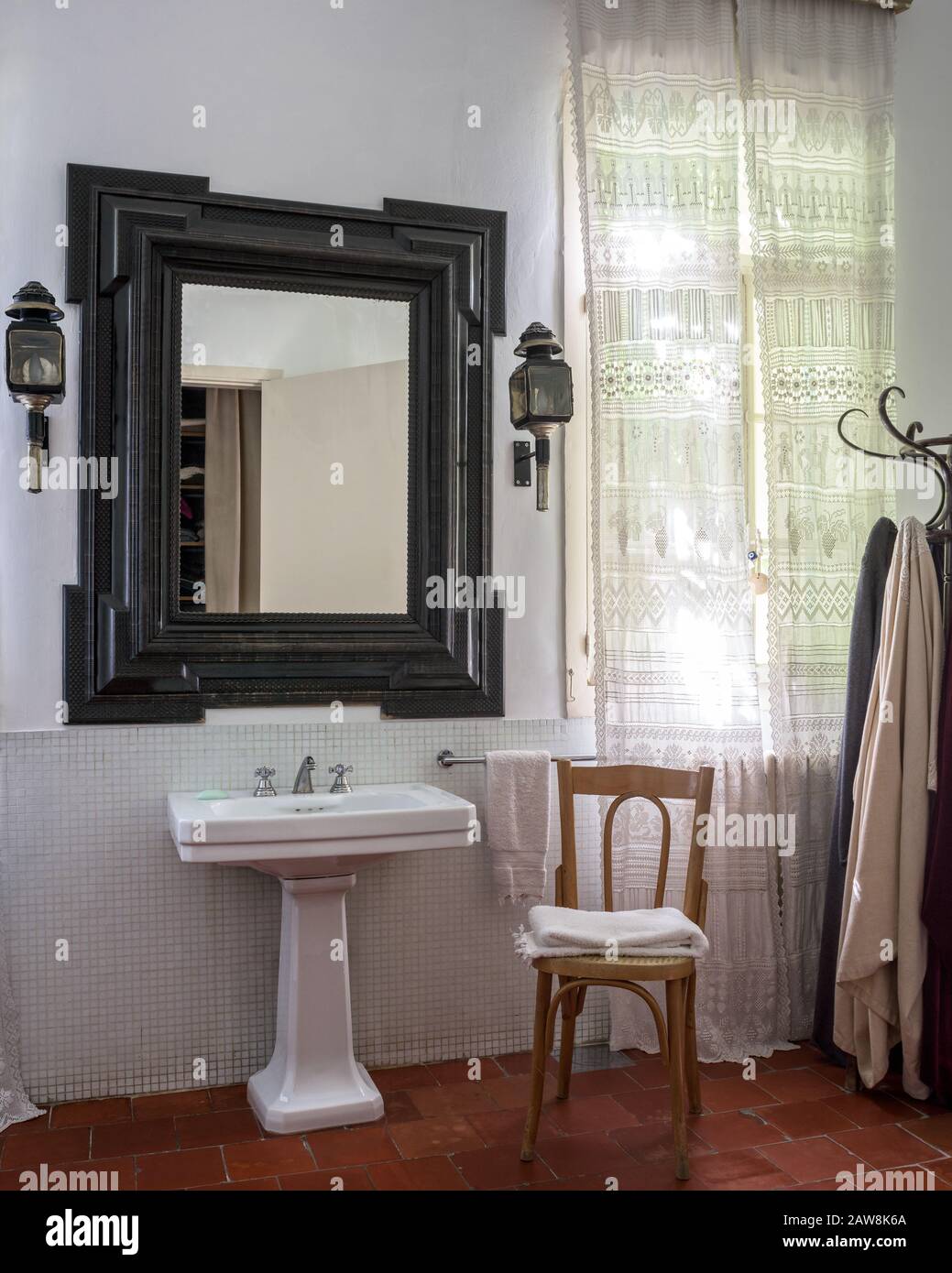 Mirror over washbasin in country style bathroom Stock Photo