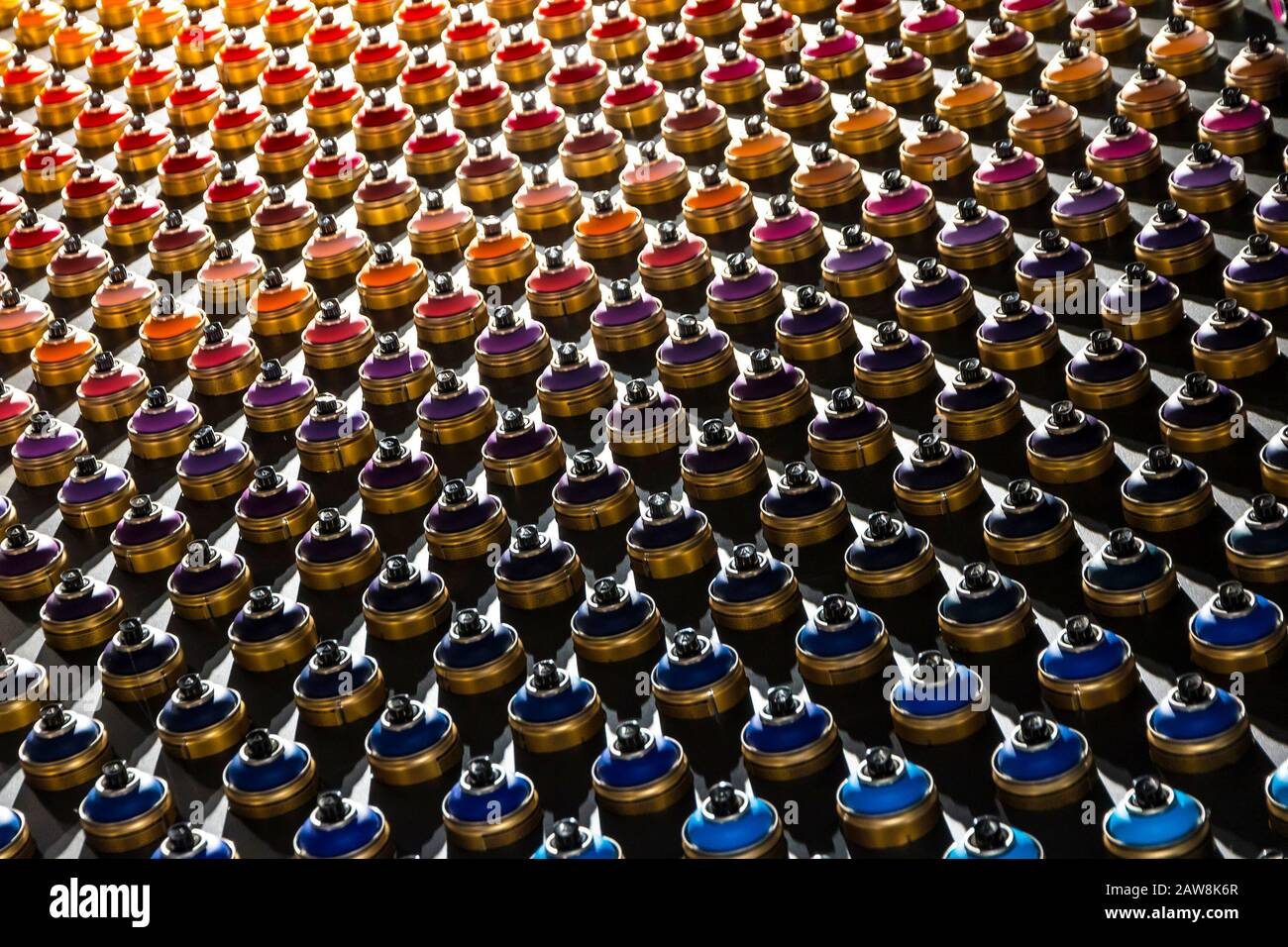 Rows of color paint spray cans placed on a black wall. Abstract colour palette Stock Photo