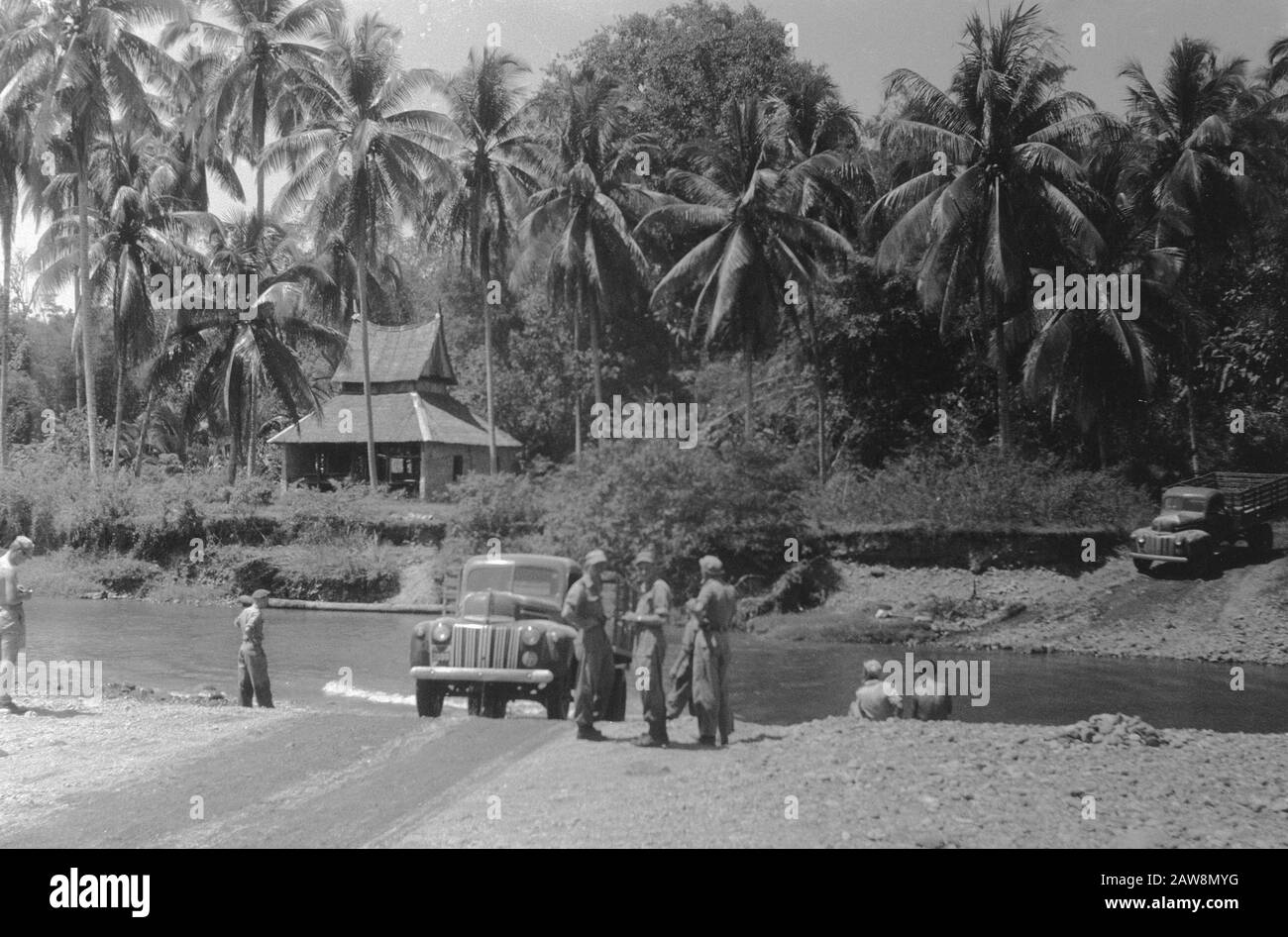 march to Fort van der Capellen and Fort de Kock (Anei Gorge)  [Army truck crosses a river at a ford over. Another is ready to stabbing over] Date: December 29, 1948 Location: Bukittinggi, Indonesia, Dutch East Indies, Sumatra Stock Photo