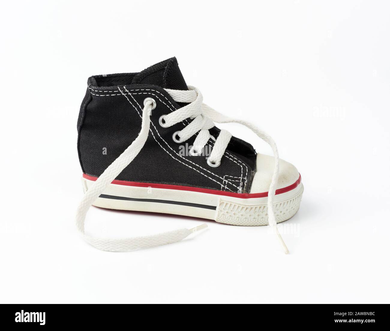 black textile children's sneaker with white untied shoelaces on a white ...