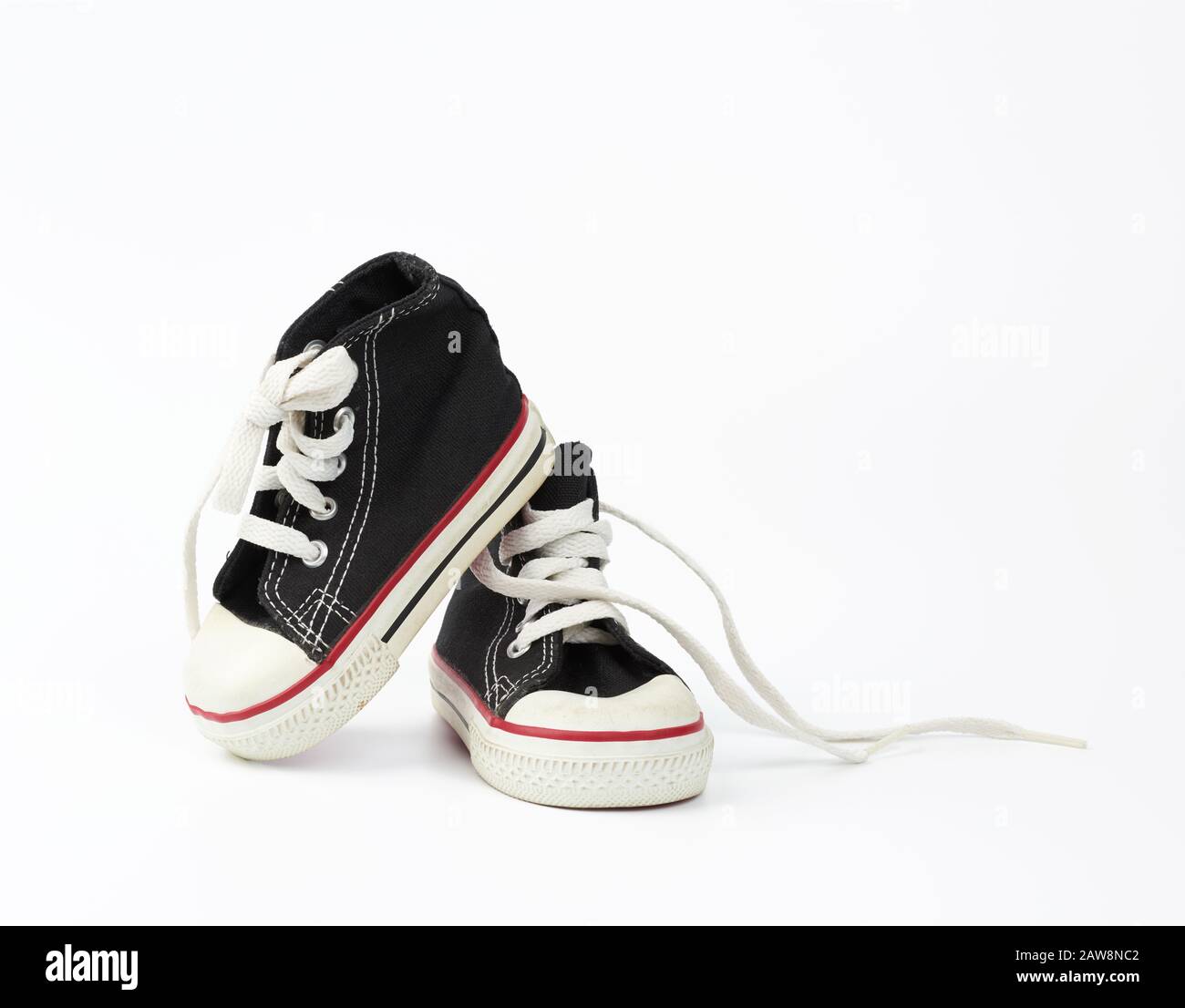 pair of black textile children's sneakers with white untied shoelaces ...