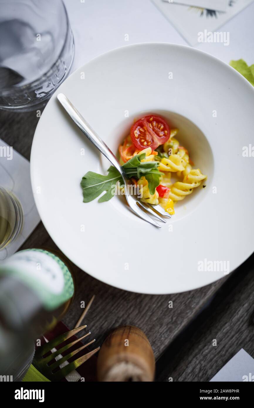 Minimalist pasta dish on a messy unorganised table Stock Photo