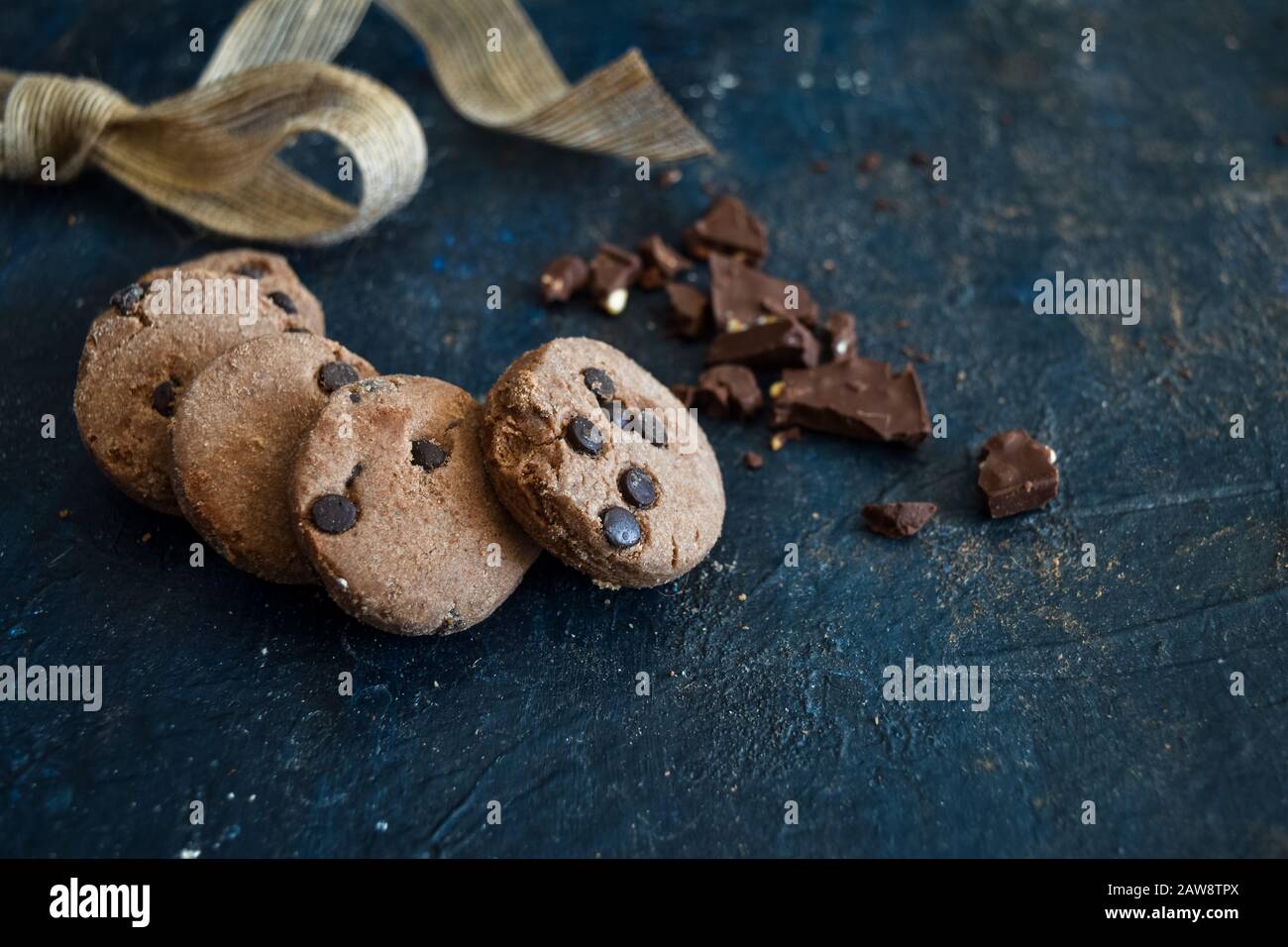 Fresh homemade Chocolate chip cookies with ribbon and dark chocolate, gluten free, cafe, bakery, top view on a dark rustic background, copy space. Stock Photo