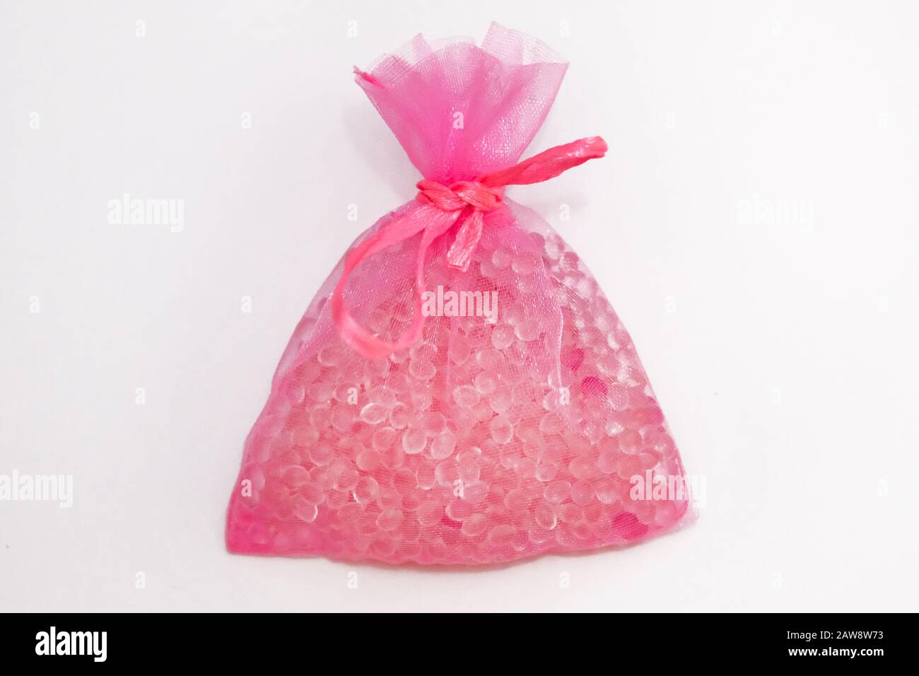 Pink pouch on a white background, flavor hanging in a car. Air fresheners are made in the form of flavored granules placed in bright sachets. Car air Stock Photo