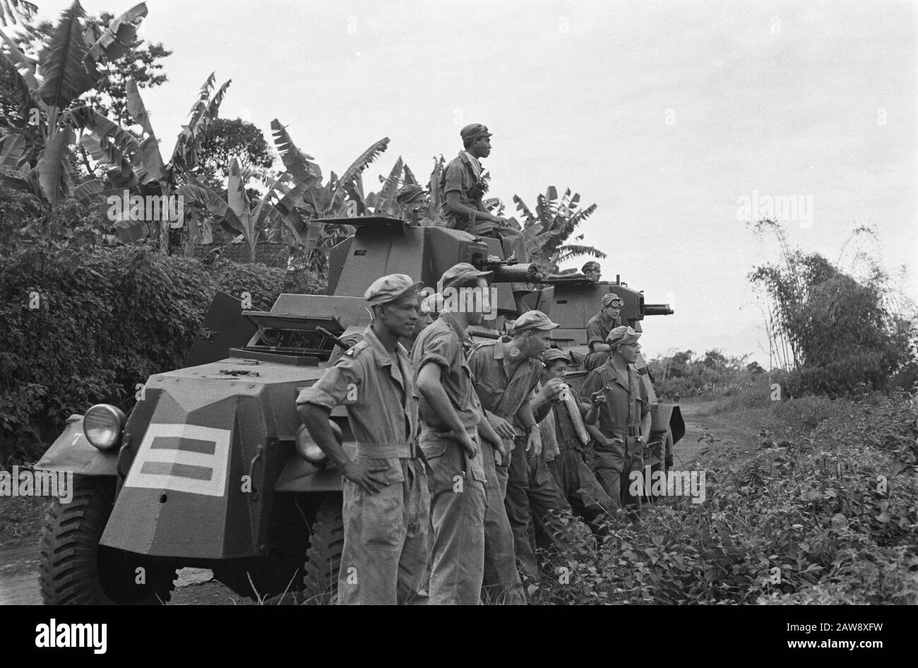 Veterans on the road  [Armored Car Platoon KNIL] Look, you can see that going around Bandung. Corporal H. Smidt from Suriname, Jan Meyer from Nijmegen, Lieutenant Crince le Roy from Deventer, J. Haumabu from Ambon, JF Mattheyser The Hague, Private First Class of Soldt from The Hague with an armored vehicle at a high tjot Annotation: Marmon-Herrington Armored Vehicles Date: July 1947 Location: Indonesia, Dutch East Indies, Sumatra Stock Photo