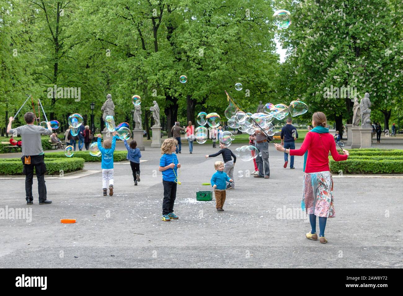 People and chidlren playing with bubbles in the Saxon Garden of Warsaw, Poland on a spring day Stock Photo